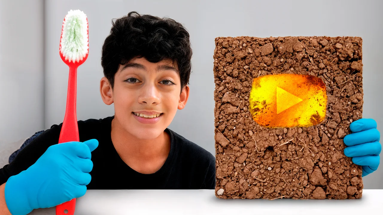 Jason holding a giant toothbrush next to a YouTube play button covered in dirt